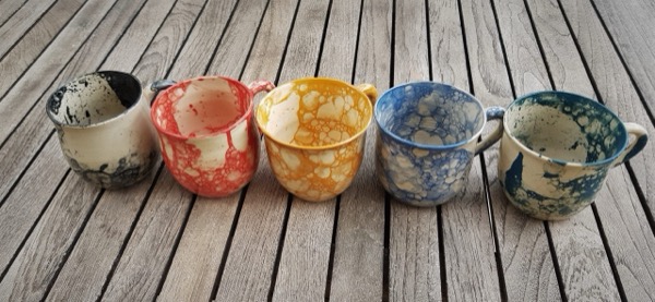 חמישה ספלי קרמיקה בעיטור מרבלינג בועתי בגוונים אדום, כחול וצהוב